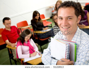 stock-photo-casual-student-or-teacher-in-a-classroom-full-of-students-5122813