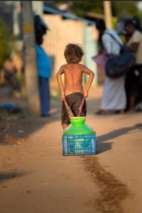 child dragging waterpot