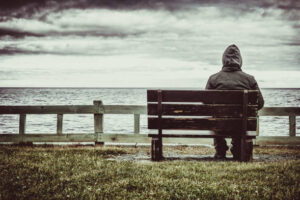 Man sitting on bench overlooking sea