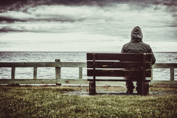 Man sitting on bench overlooking sea